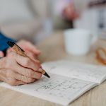 Close up of senior woman doing crossword puzzle.