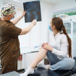 Doctor examines x-ray of patient leg. Foot and sprain concept. Sport exercise injuries.