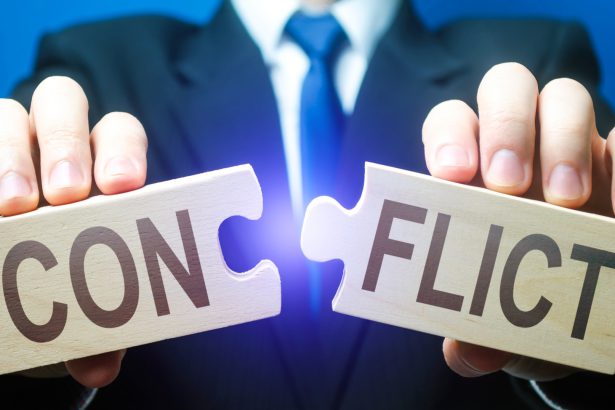 Man breaks puzzles with word Conflict. Resolution of disputes and conflicts in negotiations. Come to