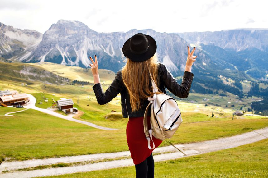 Outdoor traveling portrait of pretty cheerful young tourist woman