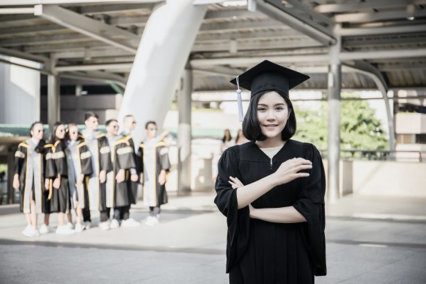 Portrait of young female graduates in square academic cap smiling happy holding diploma.