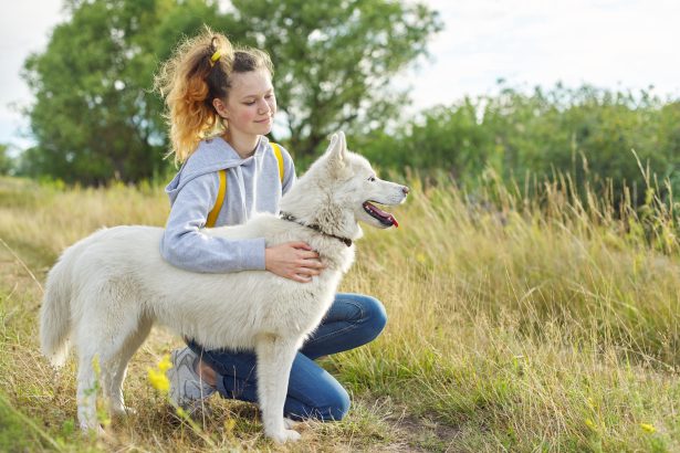 Teenager girl hugging dog, friendship care and love between child and pet